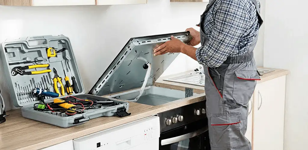 Handyman repairing a cooktop and checking wiring connections in Long Beach, CA
