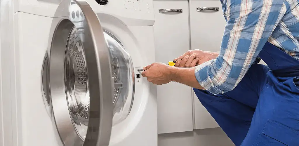 Handyman repairing a clothes dryer and checking electrical connections in Long Beach, CA