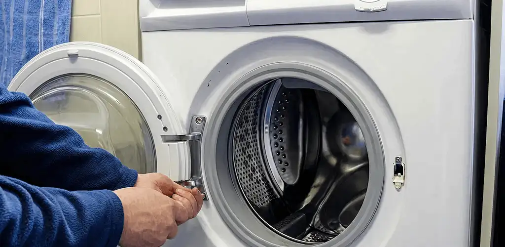 Washing machine repair handyman checking a front-load washer door and latch in Long Beach, CA
