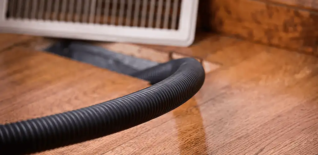 Air duct cleaning hose inserted into a floor vent for ductwork cleaning in Long Beach, CA